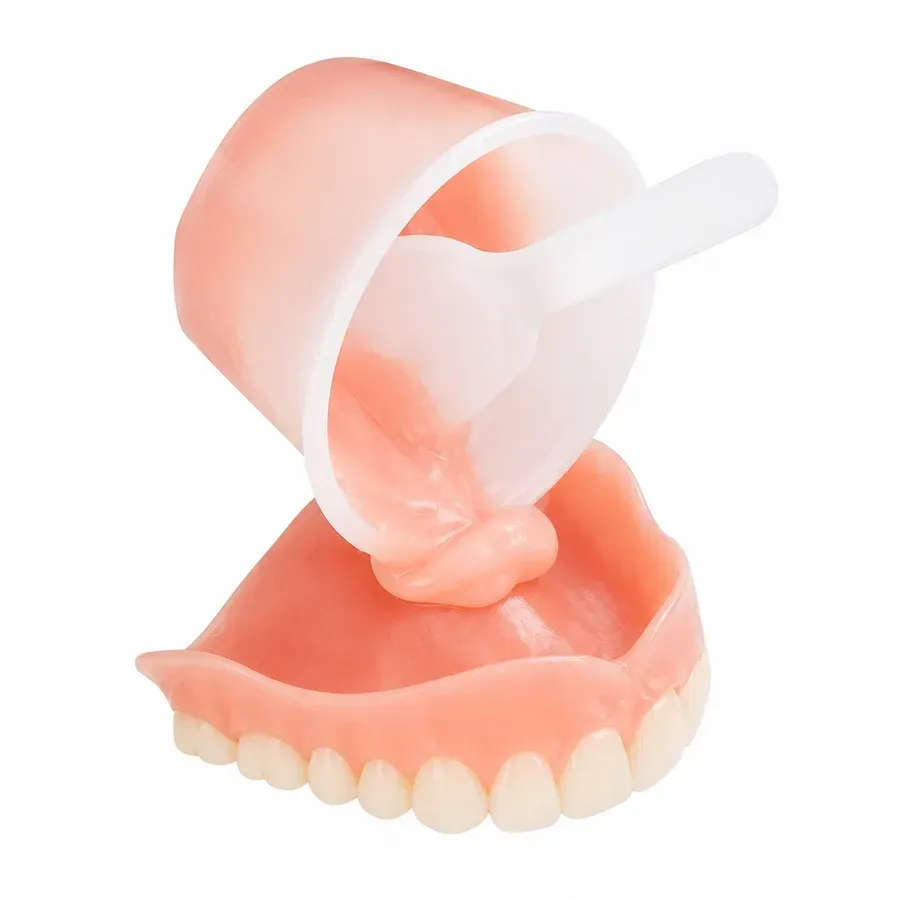 Existing denture beside a relief-and-wash reline impression on the bench before processing